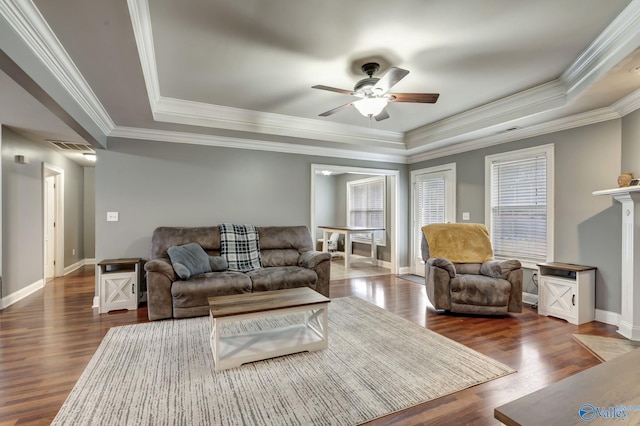 living room featuring dark wood-type flooring, ceiling fan, and a raised ceiling