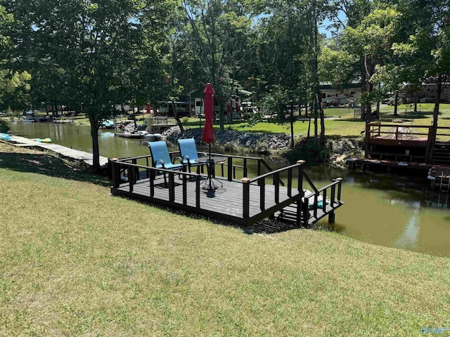 dock area featuring a water view and a lawn