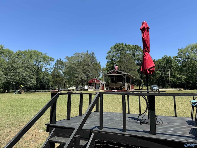 view of property's community featuring a gazebo, a lawn, and a deck