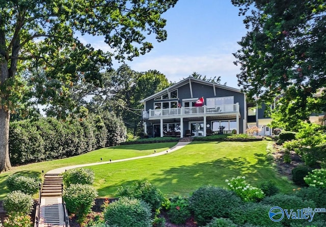 rear view of house with a balcony and a lawn