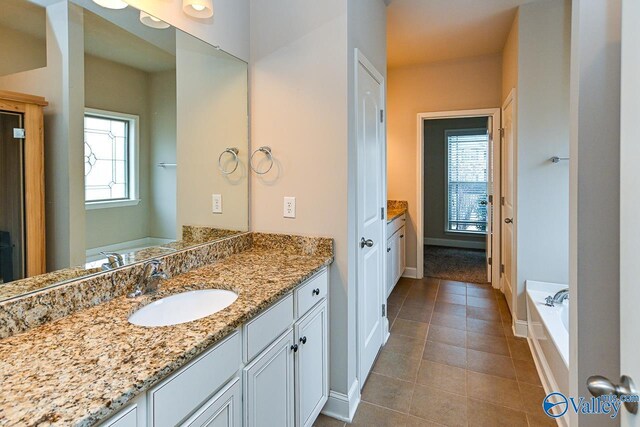 9 Leyland Dr SW, Huntsville, AL 35824 - full bathroom featuring a garden tub, vanity, baseboards, and tile patterned floors