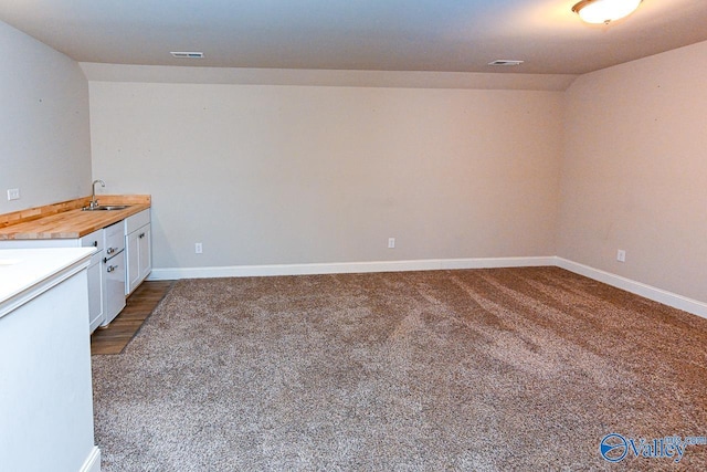 9 Leyland Dr SW, Huntsville, AL 35824 - kitchen featuring a sink, wood counters, white cabinetry, baseboards, and dark colored carpet