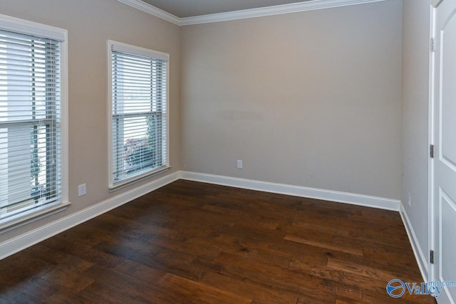 empty room with dark wood-style floors, ornamental molding, and baseboards