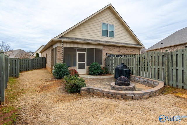 9 Leyland Dr SW, Huntsville, AL 35824 - rear view of property featuring brick siding, a sunroom, a patio area, a fenced backyard, and a fire pit