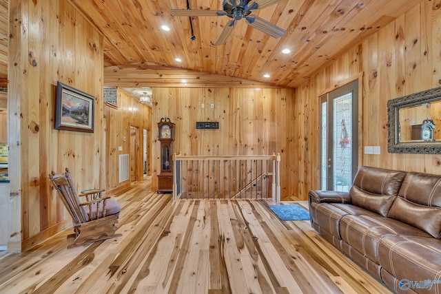 living area with wood walls, lofted ceiling, hardwood / wood-style flooring, and wooden ceiling