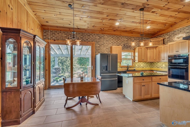 kitchen featuring a kitchen island, high end fridge, double oven, decorative light fixtures, and brick wall