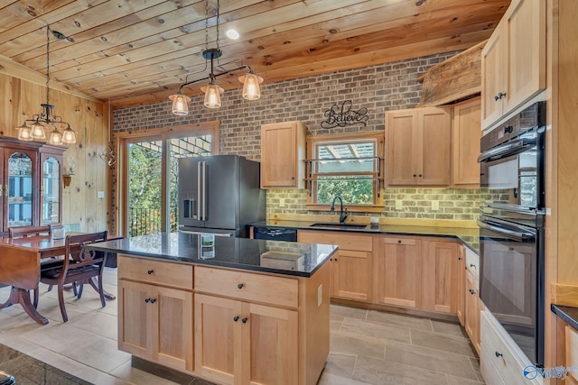 kitchen featuring a kitchen island, light brown cabinets, sink, black appliances, and decorative light fixtures