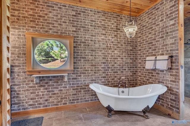 bathroom with a bathtub, wood ceiling, and brick wall