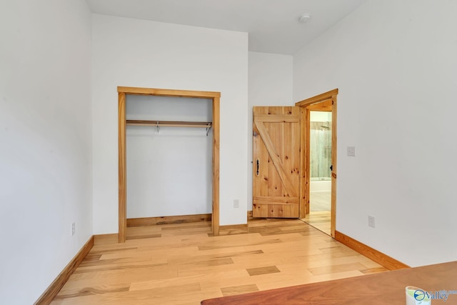 unfurnished bedroom featuring light hardwood / wood-style floors and a closet