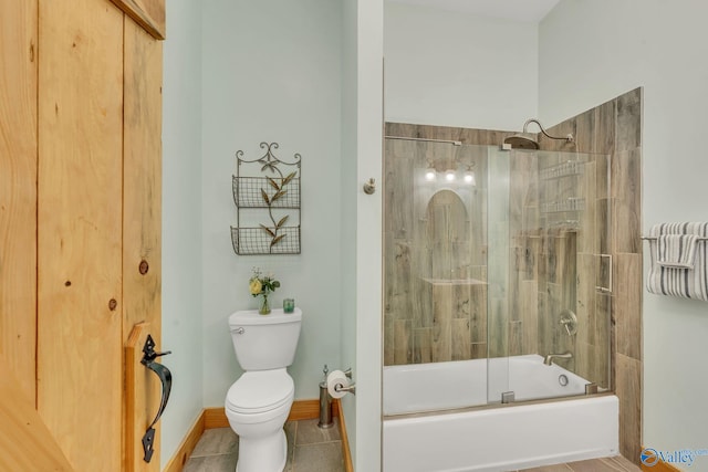 bathroom with toilet, enclosed tub / shower combo, and tile patterned floors