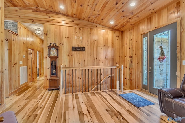 entryway featuring light hardwood / wood-style flooring, wood walls, lofted ceiling, and wood ceiling