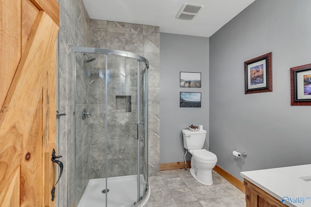 bathroom with toilet, an enclosed shower, vanity, and tile patterned floors