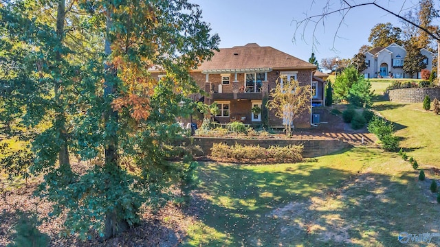 back of property featuring a lawn and a balcony