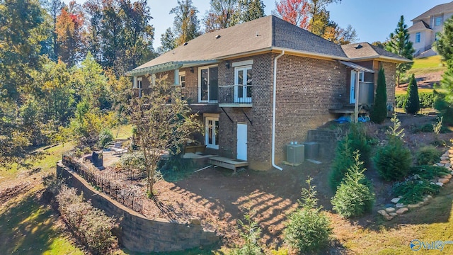 rear view of house featuring a balcony and central air condition unit