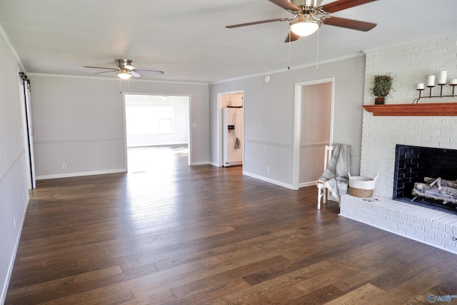 living room with a ceiling fan, crown molding, a fireplace, wood finished floors, and baseboards