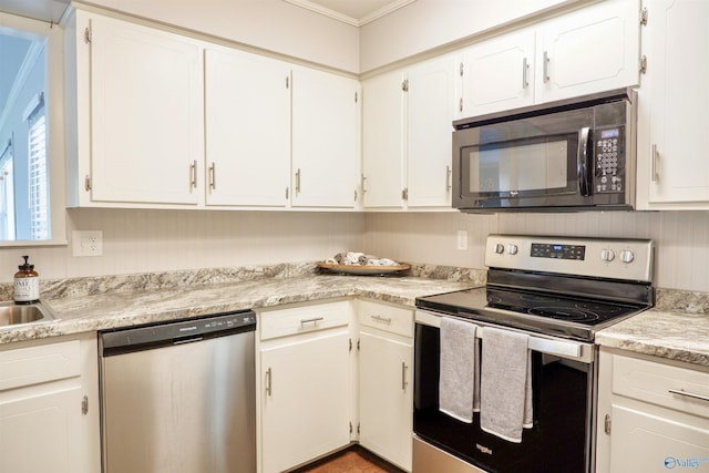 kitchen featuring crown molding, appliances with stainless steel finishes, white cabinets, and light countertops
