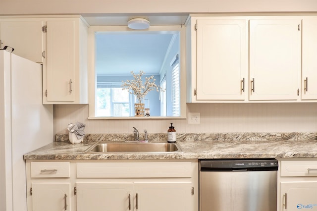 kitchen featuring white cabinets, light countertops, stainless steel dishwasher, and a sink