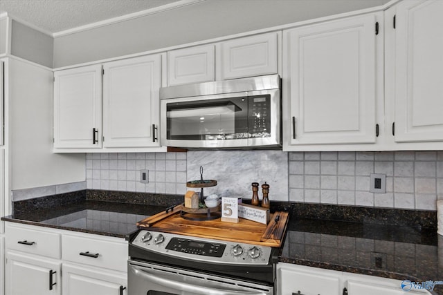 kitchen featuring a textured ceiling, ornamental molding, appliances with stainless steel finishes, white cabinetry, and backsplash