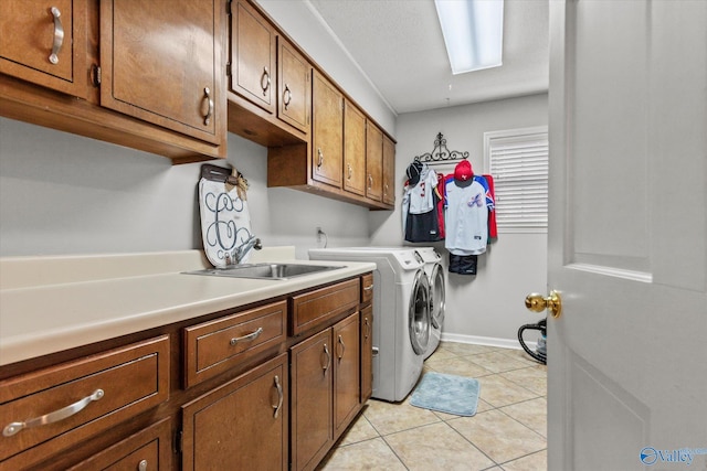 laundry area with independent washer and dryer, baseboards, a sink, cabinet space, and light tile patterned floors