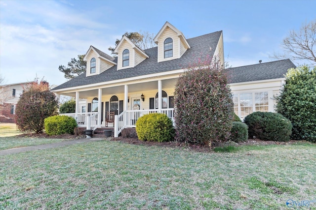 cape cod home with a porch, roof with shingles, and a front lawn