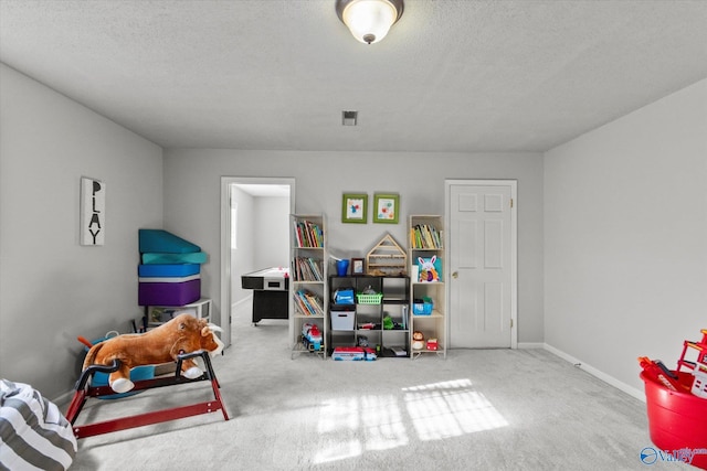 playroom featuring baseboards, carpet flooring, a textured ceiling, and visible vents