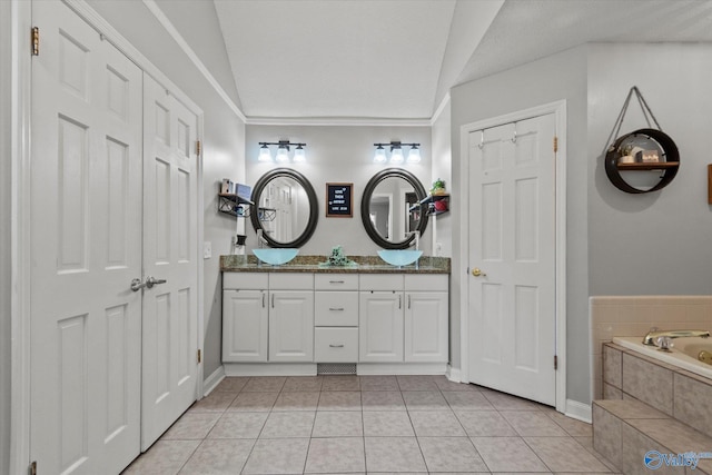 bathroom with lofted ceiling, tiled tub, tile patterned flooring, and double vanity