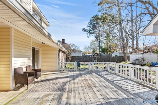 wooden terrace with a fenced backyard, a shed, and an outdoor structure