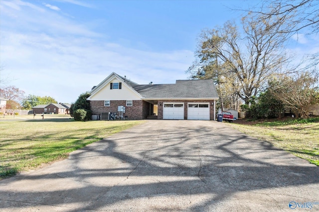 view of front facade with driveway, a front yard, an attached garage, and brick siding