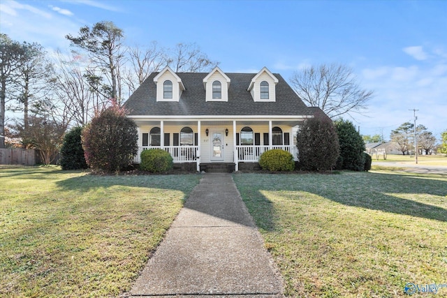 new england style home featuring a front lawn, fence, a porch, and roof with shingles