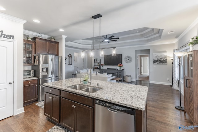 kitchen featuring sink, stainless steel appliances, crown molding, a tray ceiling, and a kitchen island with sink