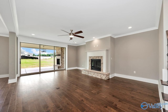 unfurnished living room featuring a brick fireplace, baseboards, and wood finished floors