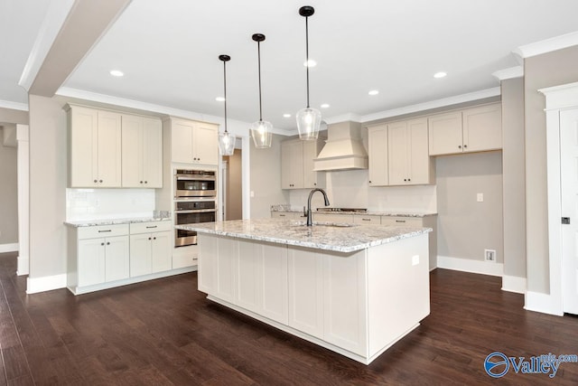 kitchen with double oven, crown molding, custom range hood, and a sink