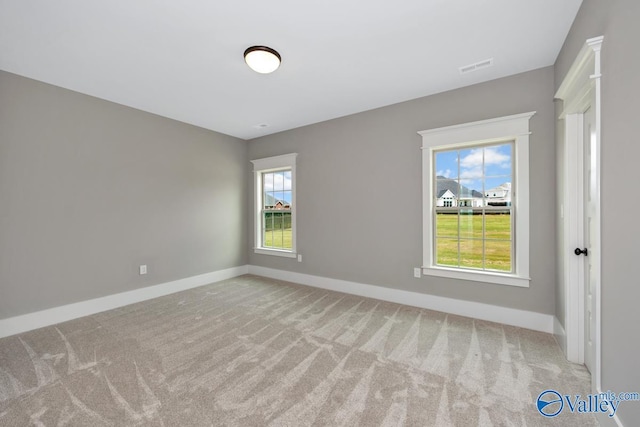 spare room featuring visible vents, baseboards, and carpet