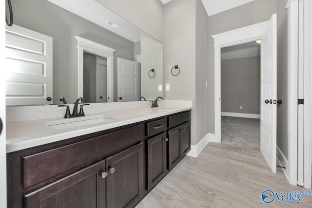 full bath with a sink, visible vents, baseboards, and double vanity