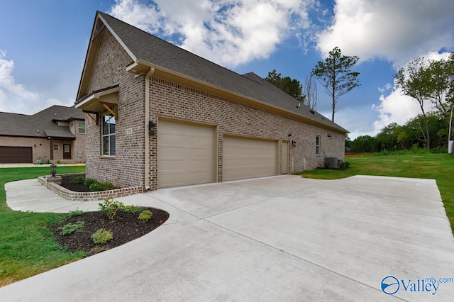 view of side of home featuring a lawn, a garage, and central AC