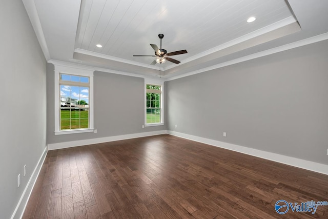 unfurnished room featuring baseboards, a raised ceiling, and dark wood-type flooring