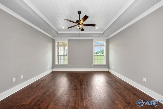 empty room with dark wood-type flooring, a tray ceiling, crown molding, baseboards, and wood ceiling