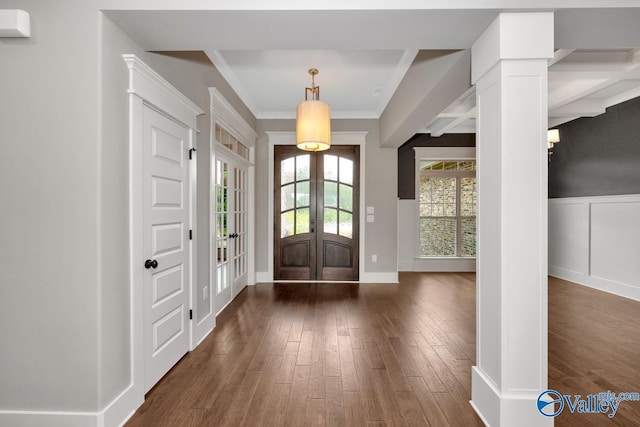 foyer featuring french doors, a decorative wall, crown molding, wainscoting, and dark wood-style flooring