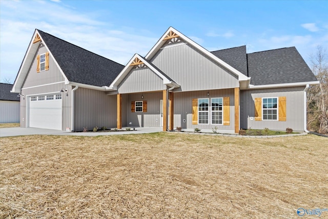 view of front of house with a front yard, a porch, and a garage