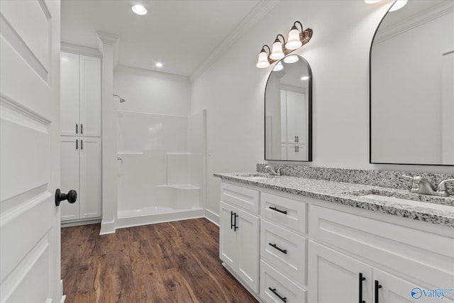 bathroom featuring vanity, a shower, crown molding, and hardwood / wood-style floors