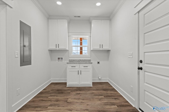 laundry area featuring dark hardwood / wood-style flooring, electric dryer hookup, hookup for a washing machine, electric panel, and crown molding