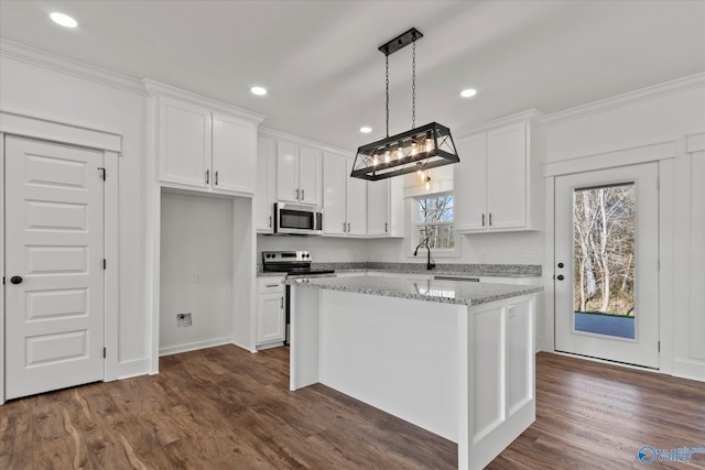 kitchen with pendant lighting, a kitchen island, white cabinetry, light stone countertops, and stainless steel appliances