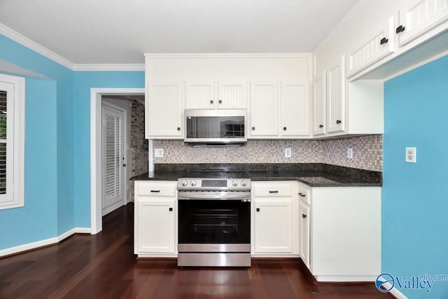 kitchen with white cabinets, appliances with stainless steel finishes, tasteful backsplash, and dark wood-style floors