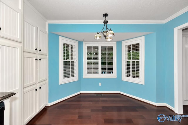 unfurnished dining area with dark wood-style floors, a textured ceiling, baseboards, a notable chandelier, and crown molding