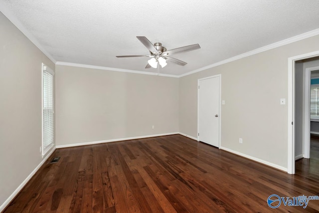 spare room featuring dark wood-style flooring, baseboards, visible vents, ceiling fan, and ornamental molding