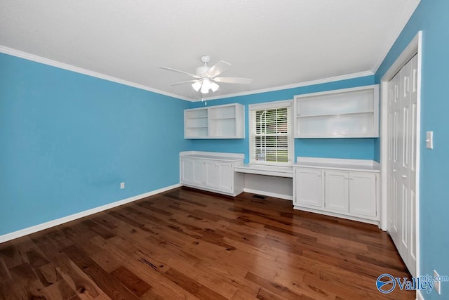 interior space featuring dark wood-style floors, baseboards, built in study area, ceiling fan, and crown molding