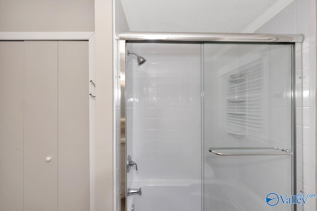 bathroom with shower / bath combination with glass door
