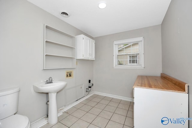 clothes washing area with laundry area, visible vents, light tile patterned floors, baseboards, and washer hookup