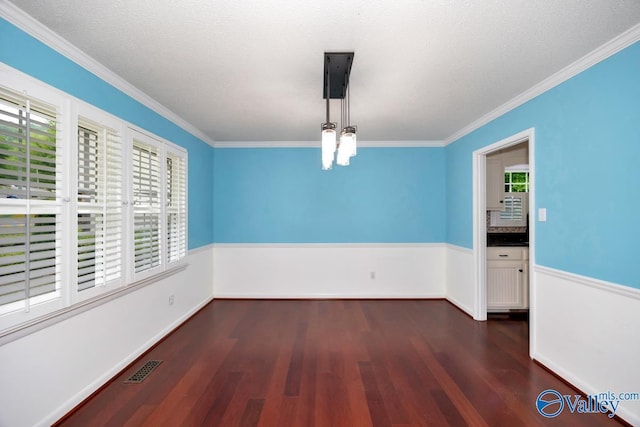 empty room with a wealth of natural light, crown molding, and dark wood-style floors