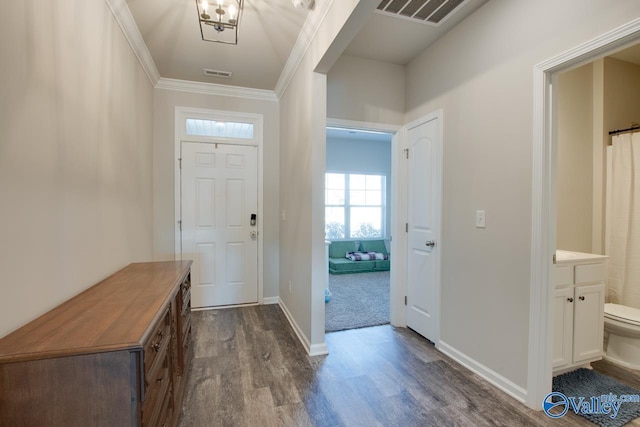 foyer entrance with an inviting chandelier, ornamental molding, and hardwood / wood-style flooring